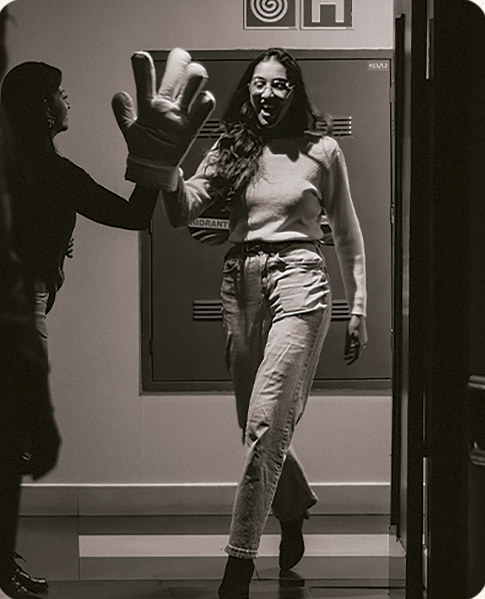 Uma mulher sendo recebida com um cumprimento na entrada do cinema